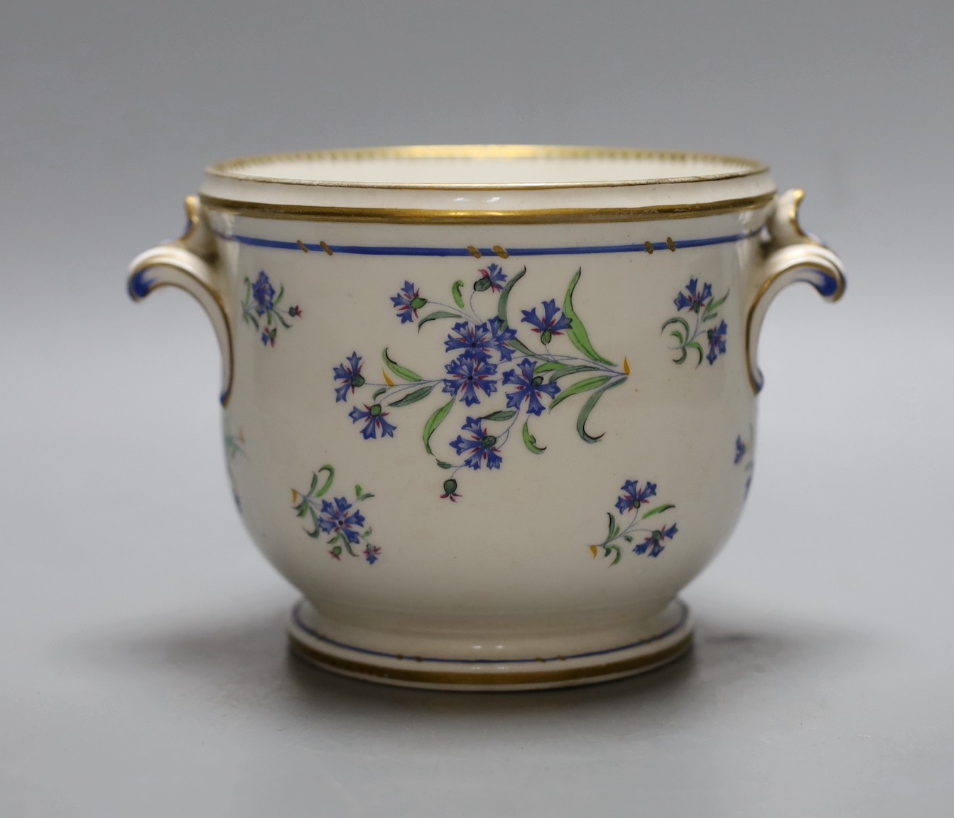 An early 19th century Paris porcelain cache pot or glass cooler with two handles painted with corrnflowers, 9.5 cms high